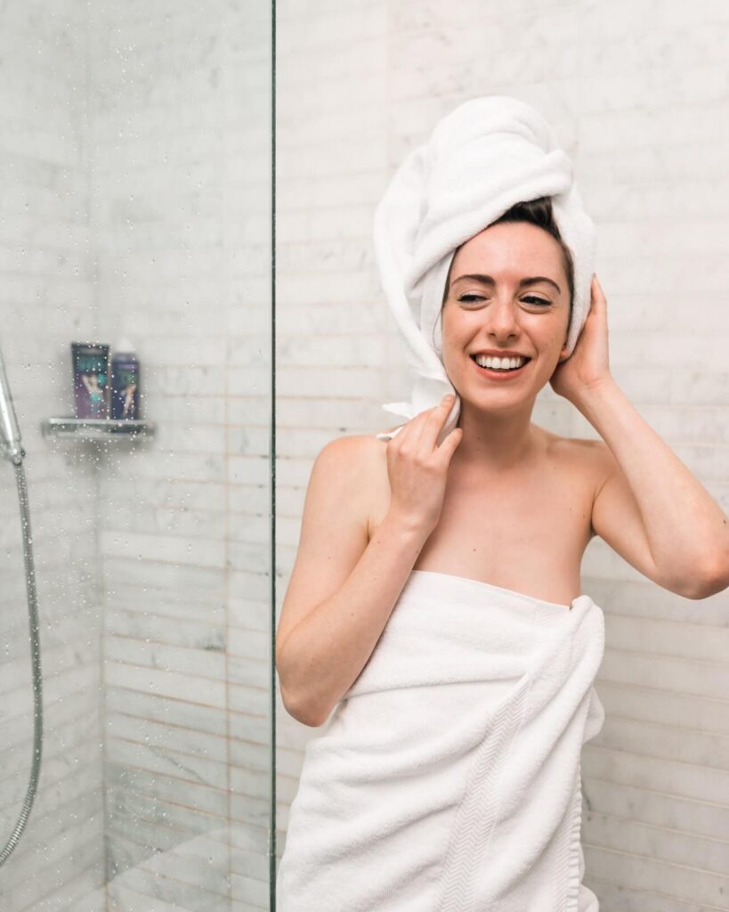 woman wrapped in a towel exiting a shower