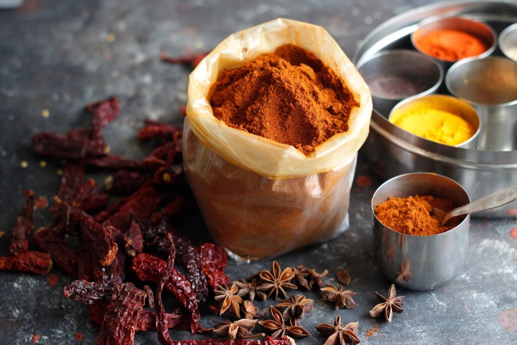 colorful spices including turmeric on a kitchen counter