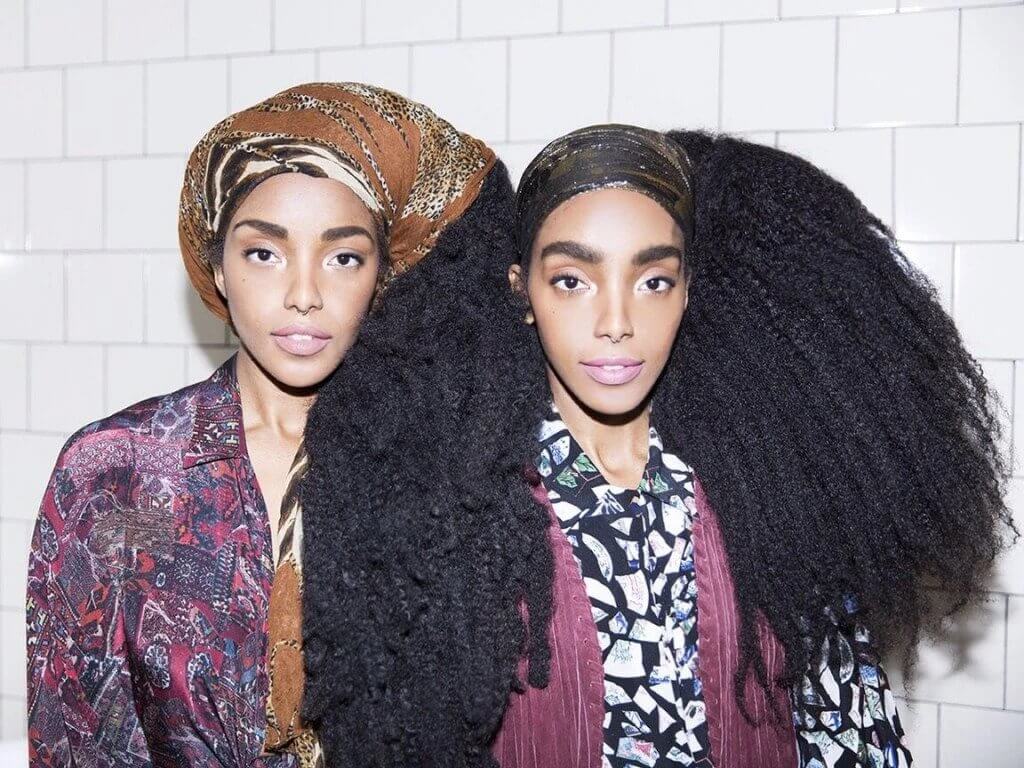 two Black women with long curly hair