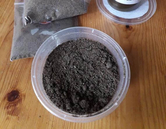 chebe powder in a plastic container on a wooden table