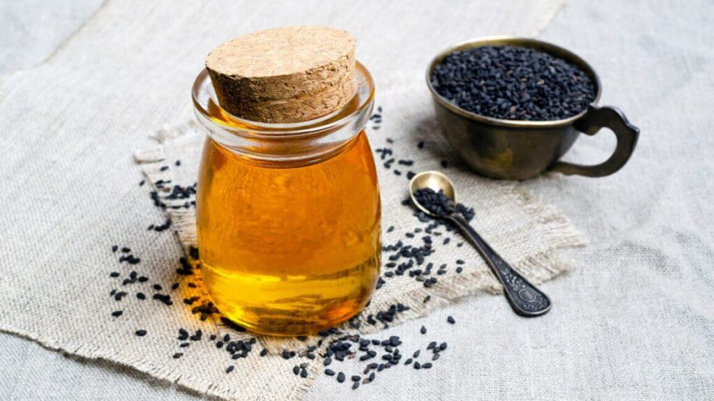 jar of black seeds with a cup of black seeds in the background