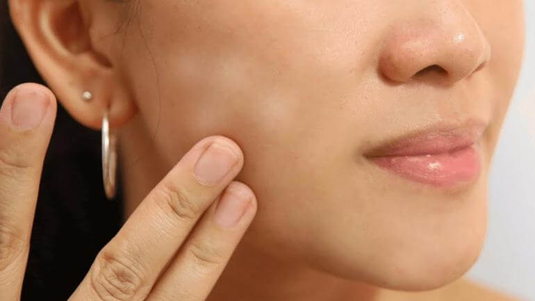 close up of the side of a woman's face and fingers