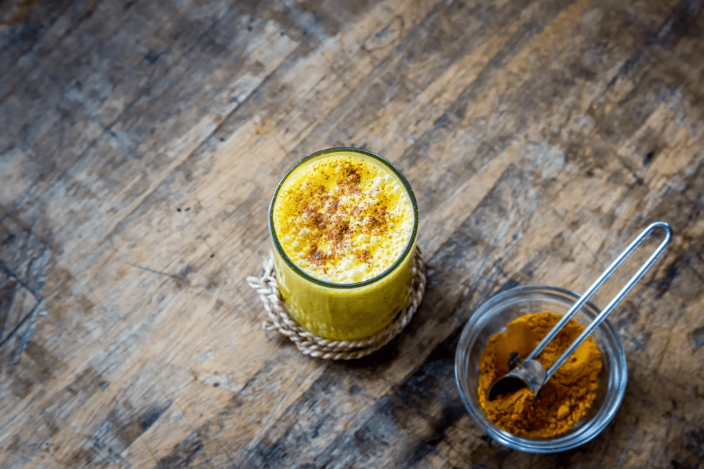 flat lay of turmeric latte and turmeric powder in a bowl