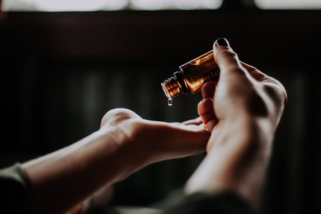 Close up of woman pouring essential oil into hand