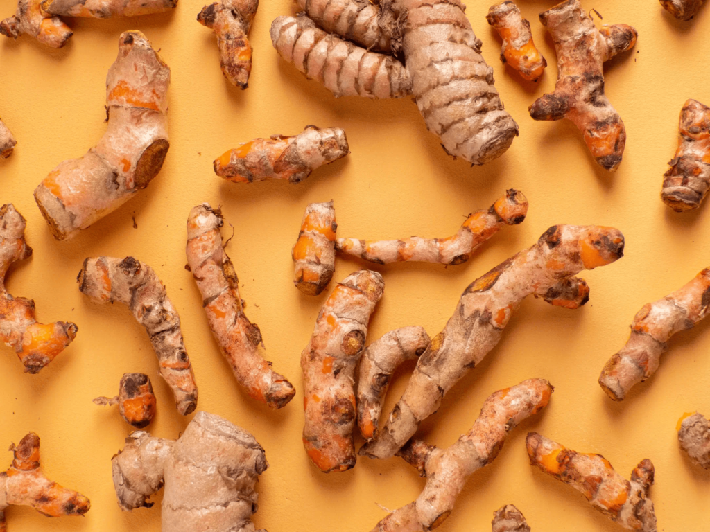 flat lay of turmeric root on an orange background