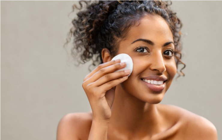 young women wiping her face off with a cotton pad