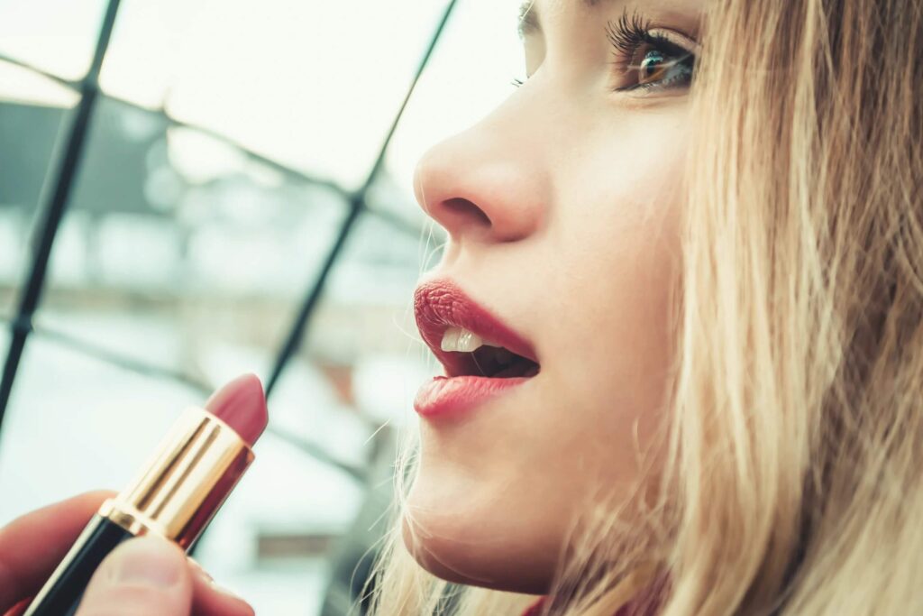 side view of a woman holding a lipstick tube to her lips gluten free beauty products 