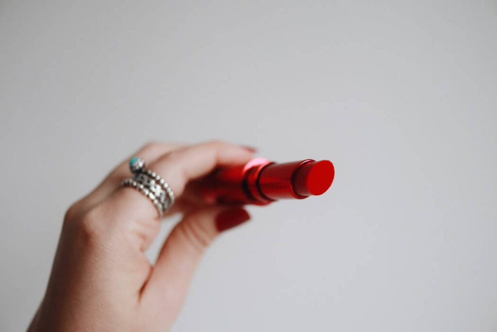 hand holding a tube of red lipstick