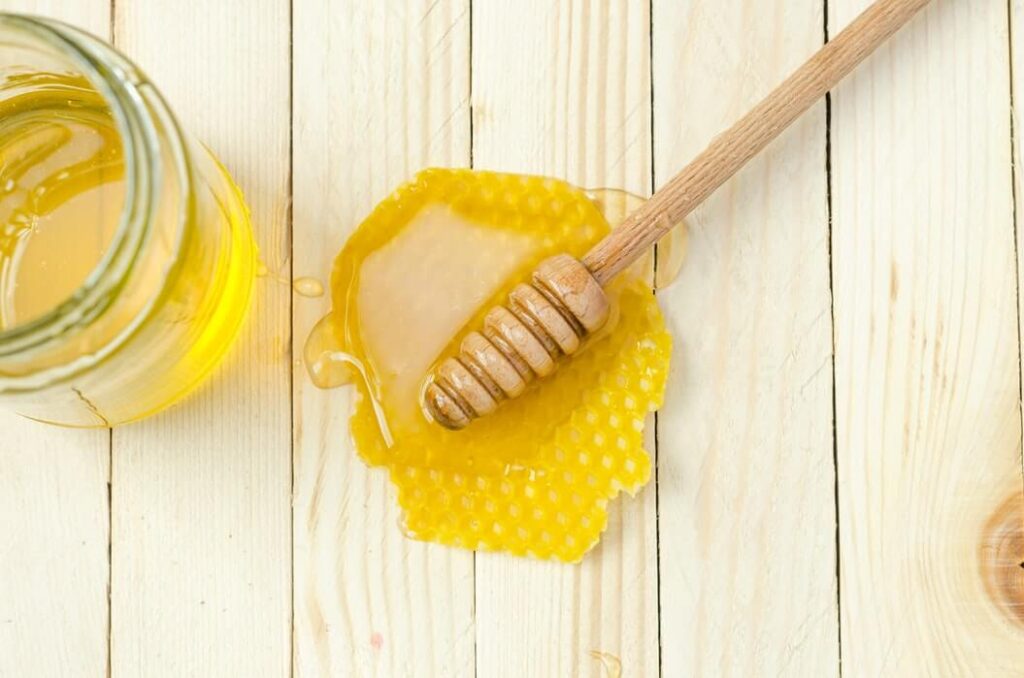 flat lay of a honey dipper on top of a honey comb