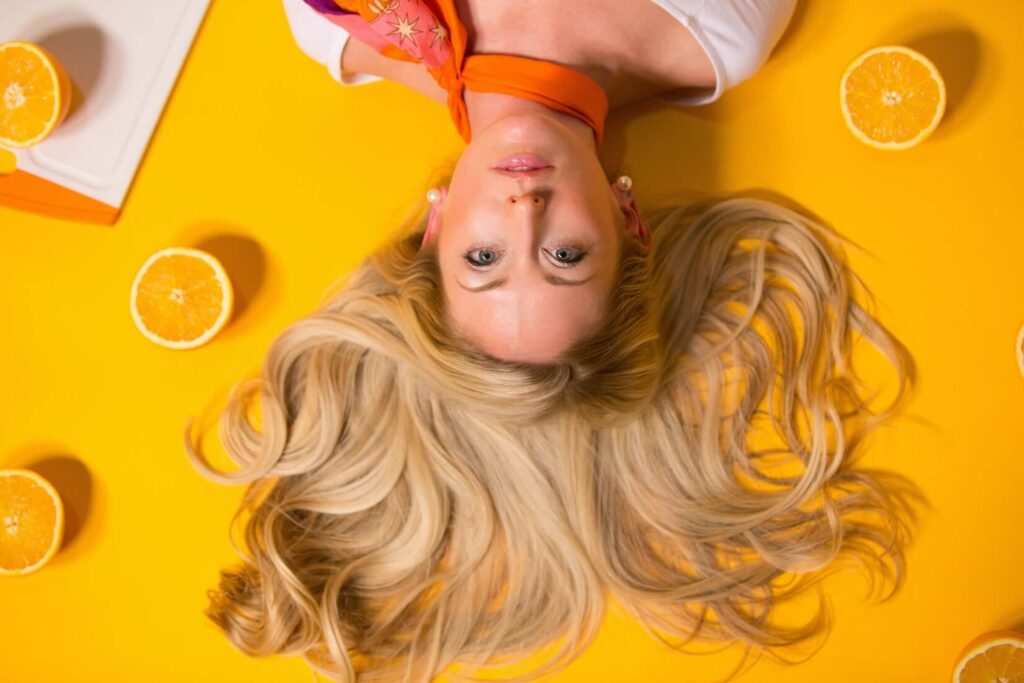 photo of a woman laying on orange background