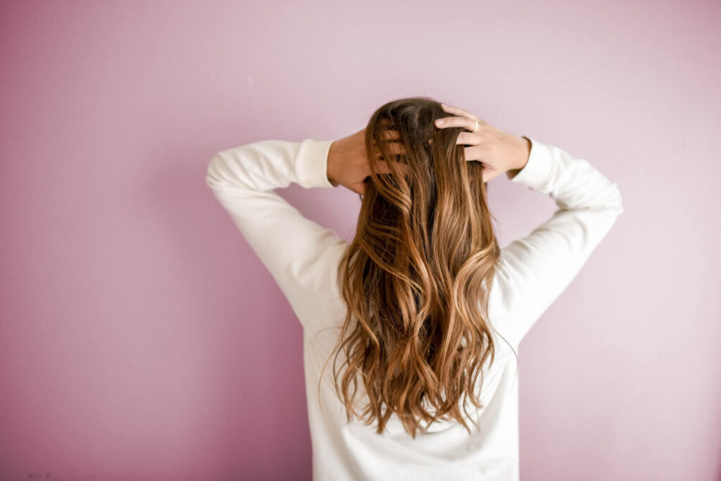 a woman facing back with hands on her hair