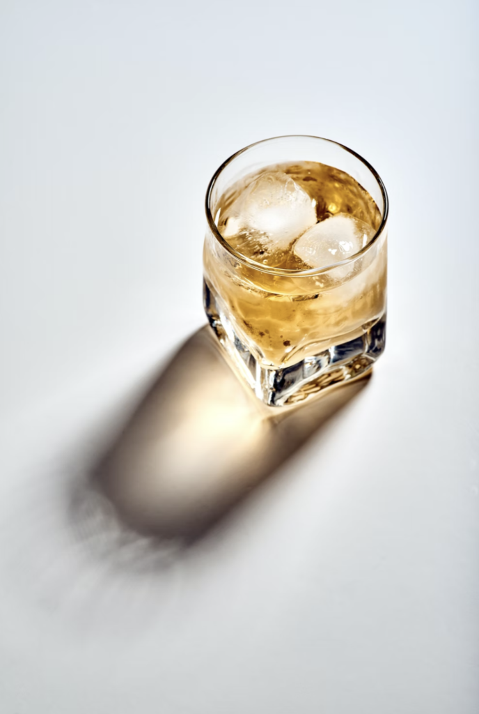 a glass with liquid and ice cubes Effects of Alcohol on Skin