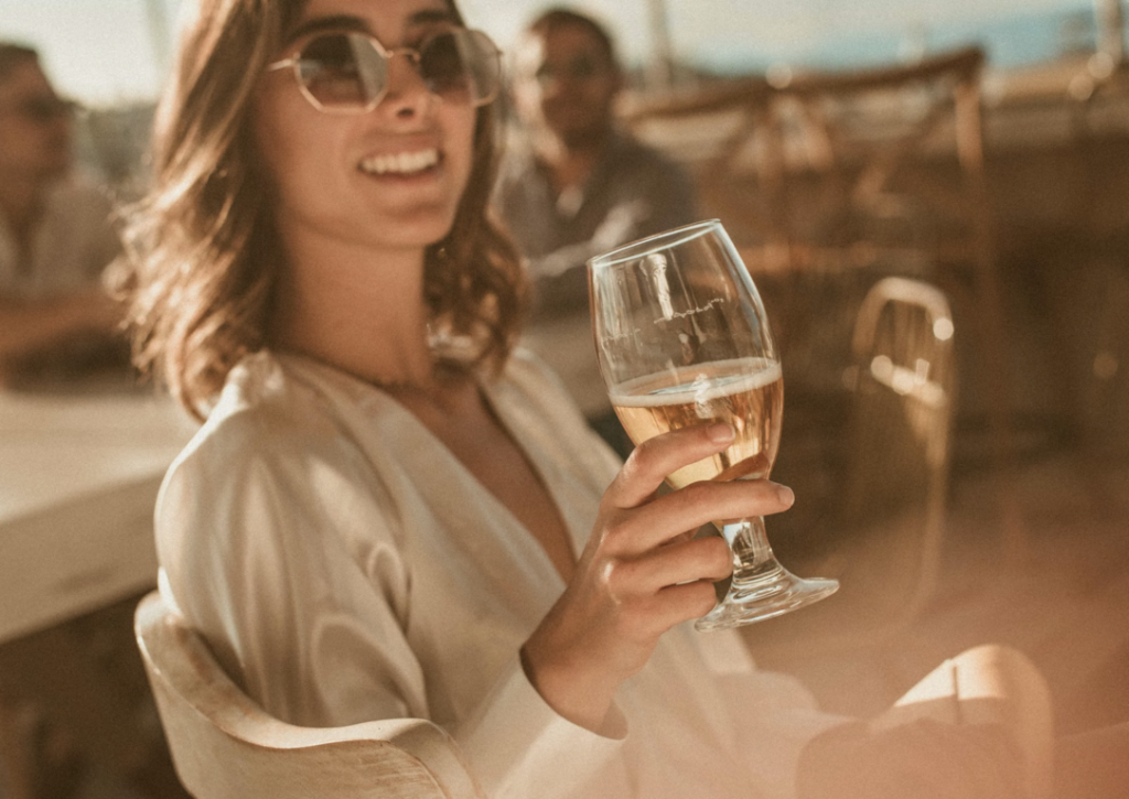 a woman holding a glass Effects of Alcohol on Skin