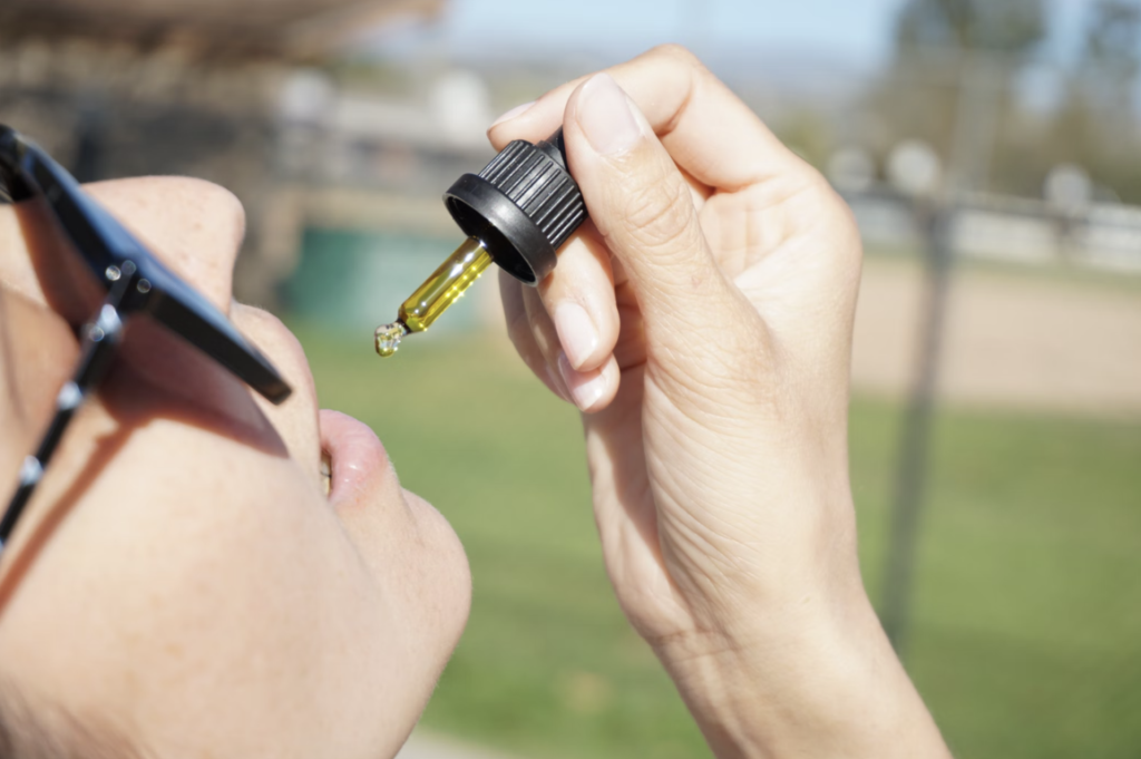 woman dropping oil in her mouth Marijuana and Skin Health